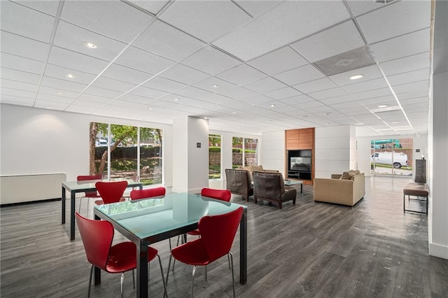 dining space featuring a paneled ceiling and dark hardwood / wood-style floors