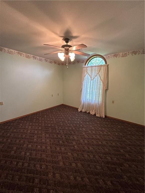 carpeted spare room featuring ceiling fan