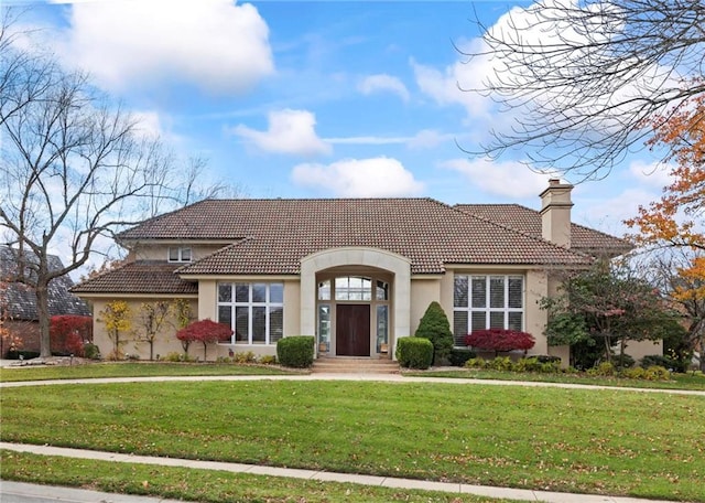 mediterranean / spanish home with a front lawn