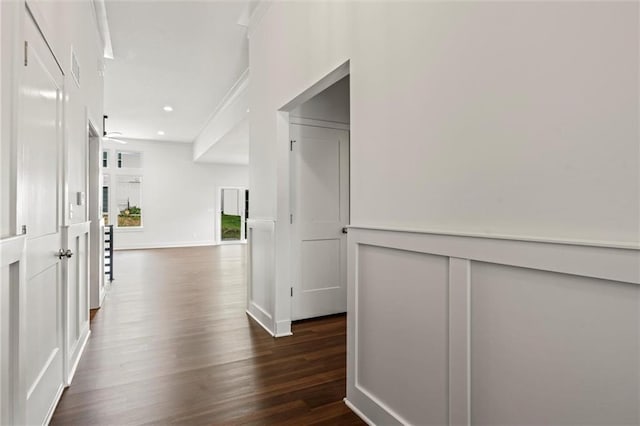 corridor with dark hardwood / wood-style flooring and ornamental molding