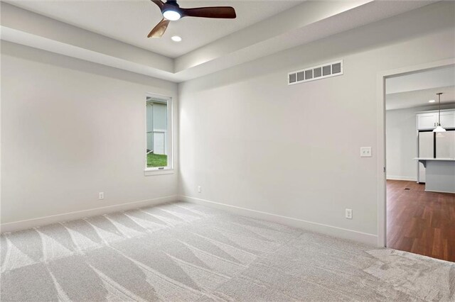 carpeted spare room with ceiling fan