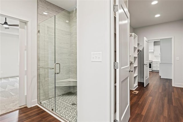 bathroom featuring hardwood / wood-style floors, walk in shower, and ceiling fan