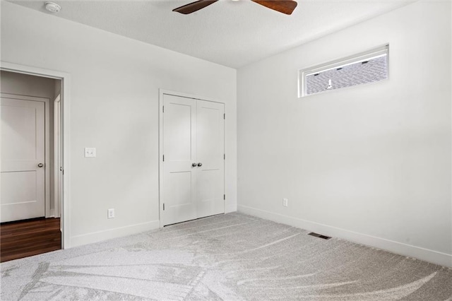 unfurnished bedroom with carpet flooring, ceiling fan, and a closet