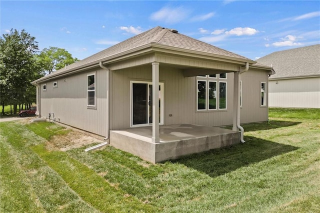 rear view of house featuring a lawn and a patio area