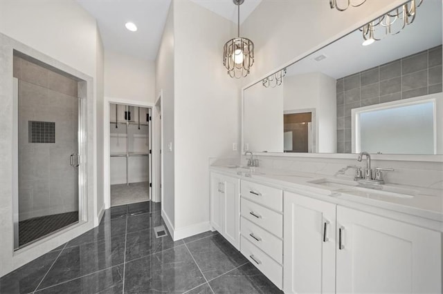 bathroom featuring a shower with door and vanity