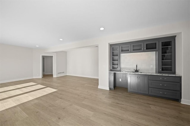 bar with hardwood / wood-style floors and sink