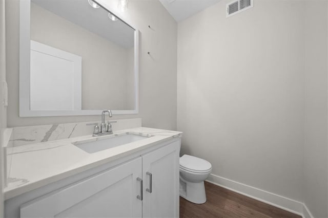 bathroom featuring hardwood / wood-style floors, vanity, and toilet