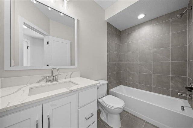 full bathroom with tile patterned floors, vanity, tiled shower / bath combo, and toilet