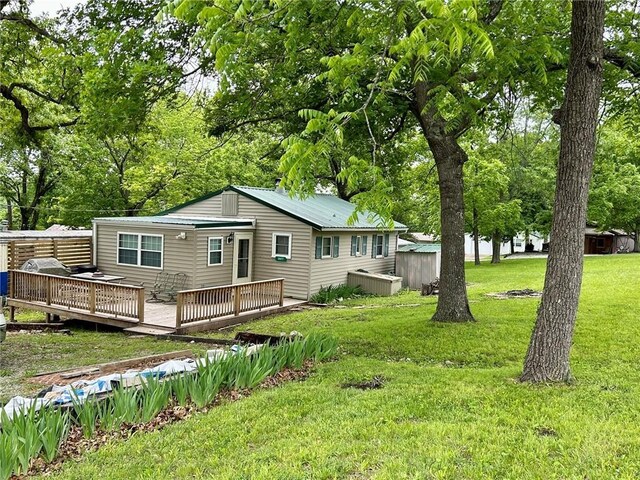 ranch-style home with a front yard and a wooden deck