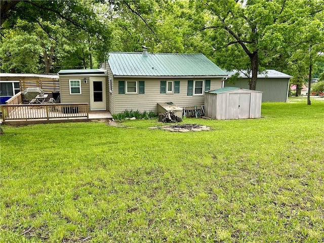 rear view of property with metal roof, an outbuilding, a storage unit, a deck, and a yard