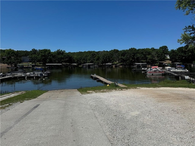 view of dock with a water view and a wooded view