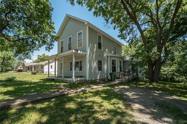 view of side of property with a lawn and covered porch