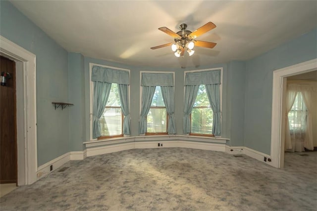 carpeted spare room featuring ceiling fan and a healthy amount of sunlight