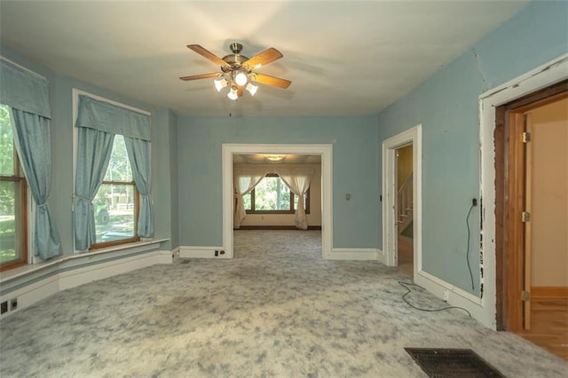 unfurnished room with ceiling fan and a healthy amount of sunlight