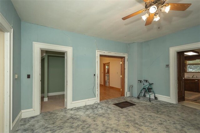 unfurnished room featuring ceiling fan, light colored carpet, and sink