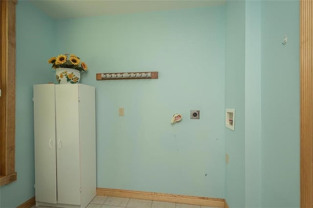 washroom featuring electric dryer hookup, cabinets, light tile patterned floors, and hookup for a washing machine