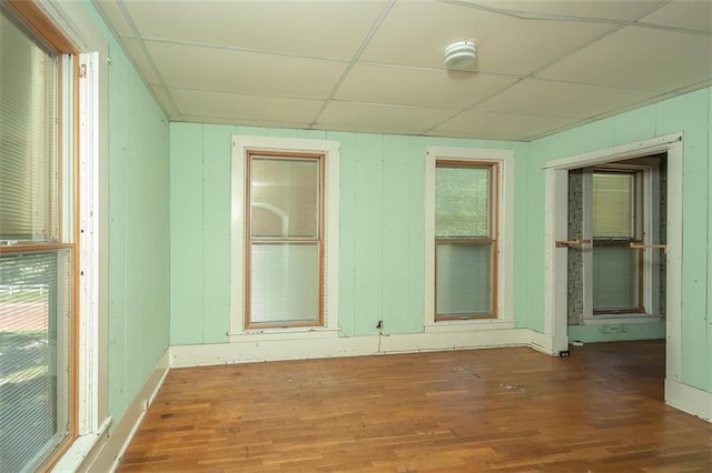 unfurnished room with a paneled ceiling and dark hardwood / wood-style floors