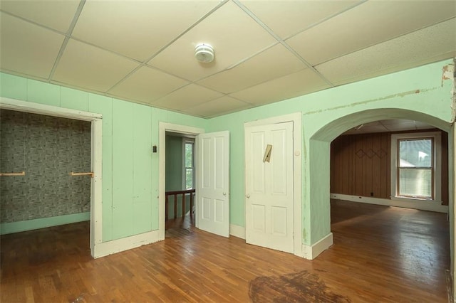 spare room featuring a paneled ceiling and dark wood-type flooring