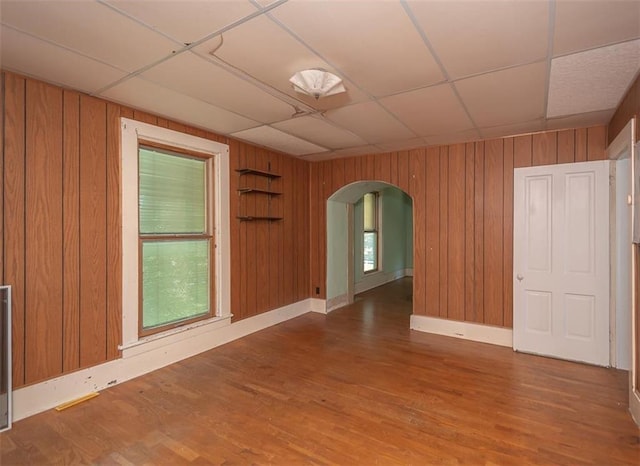 spare room featuring a drop ceiling and hardwood / wood-style flooring