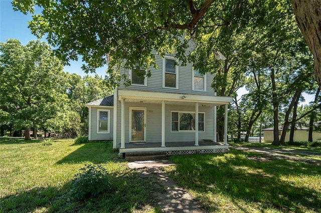 back of house featuring a lawn and covered porch