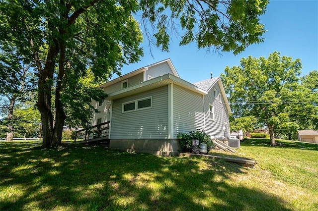 view of home's exterior featuring a yard, central AC unit, and a deck