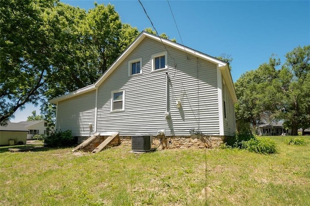 view of side of property featuring a yard and central AC unit