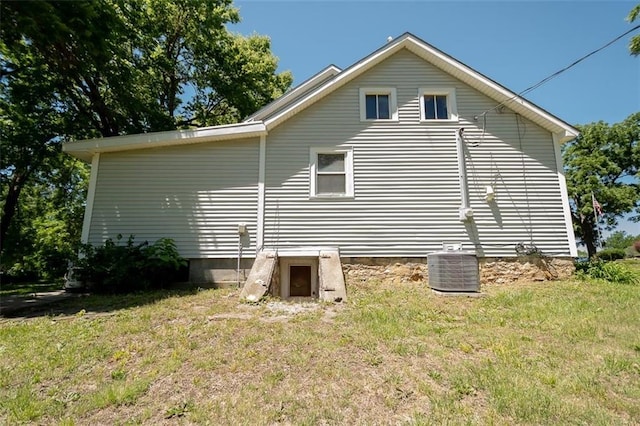 view of side of property with a yard and central AC