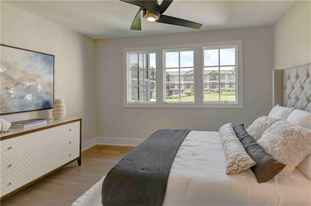 bedroom with light hardwood / wood-style floors and ceiling fan