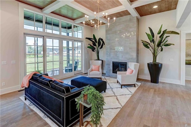 living room with beamed ceiling, wood ceiling, a tile fireplace, and coffered ceiling