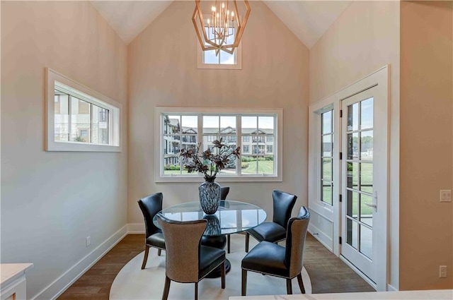 dining space featuring high vaulted ceiling, dark wood-type flooring, and a chandelier