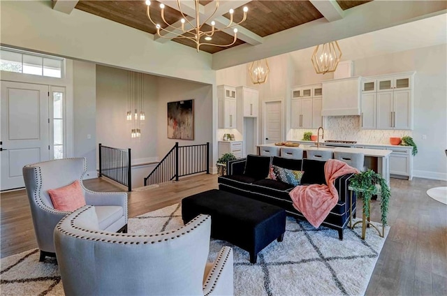 living room featuring wood ceiling, sink, light wood-type flooring, and an inviting chandelier