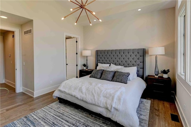 bedroom featuring an inviting chandelier and hardwood / wood-style flooring