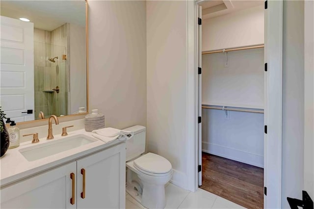 bathroom with vanity, walk in shower, hardwood / wood-style flooring, and toilet