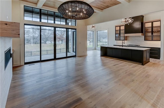 kitchen featuring wood ceiling, an island with sink, a chandelier, and light wood-type flooring