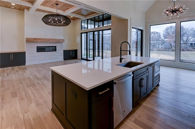 kitchen with appliances with stainless steel finishes, decorative light fixtures, a notable chandelier, and an island with sink