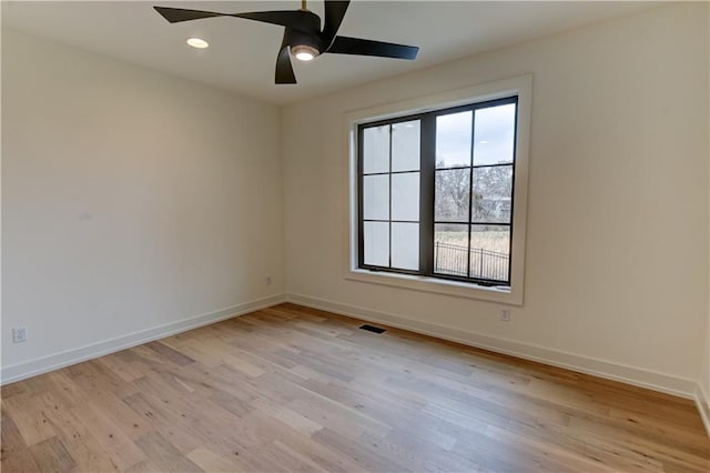 spare room with ceiling fan and light wood-type flooring