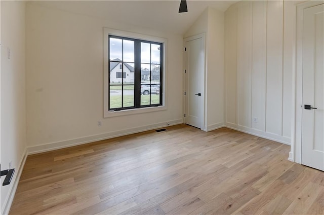 spare room with lofted ceiling, ceiling fan, and light wood-type flooring