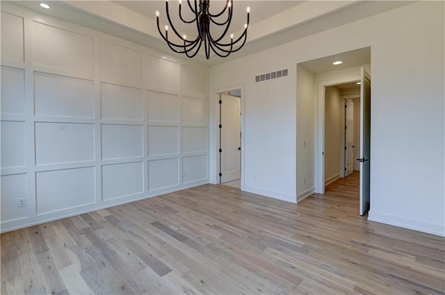 unfurnished dining area with light hardwood / wood-style flooring and an inviting chandelier