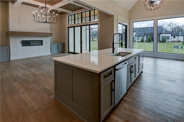 kitchen with dishwasher, an inviting chandelier, dark hardwood / wood-style flooring, an island with sink, and decorative light fixtures