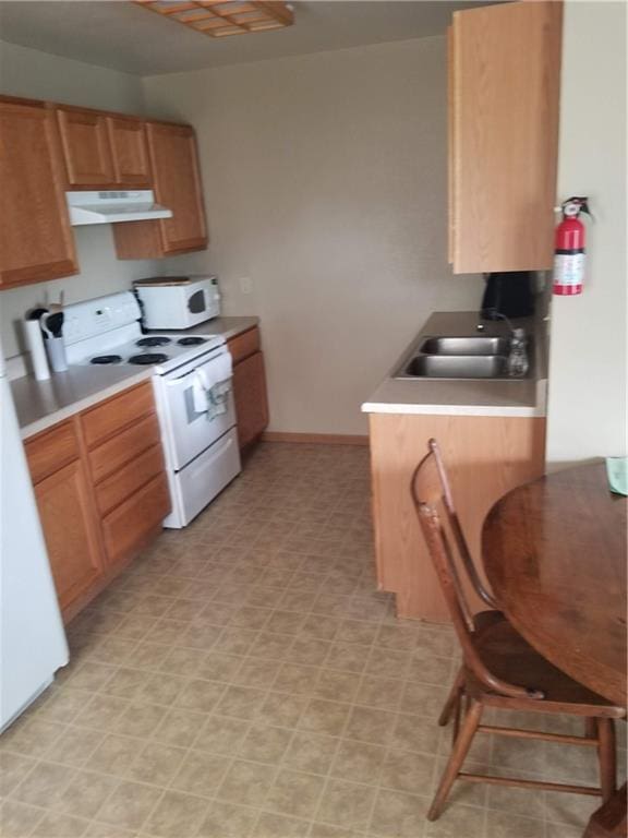 kitchen featuring light tile patterned flooring, white appliances, and sink