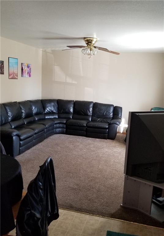 carpeted living room featuring ceiling fan