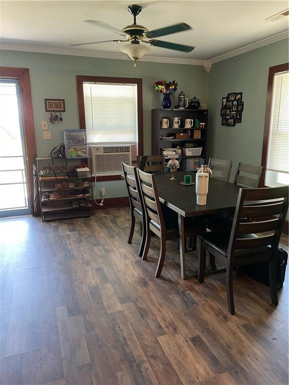 dining space with cooling unit, crown molding, ceiling fan, and dark wood-type flooring