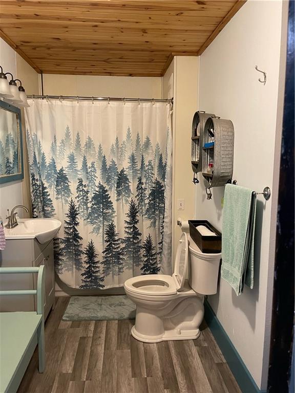 bathroom with wood ceiling, vanity, crown molding, wood-type flooring, and toilet