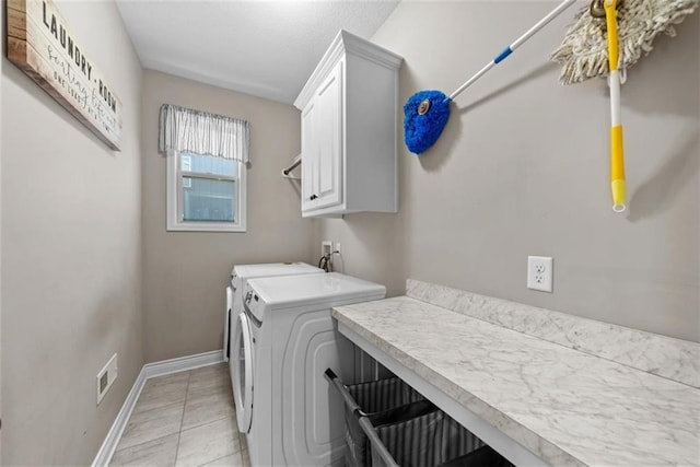 laundry room with washer and dryer, light tile patterned floors, and cabinets