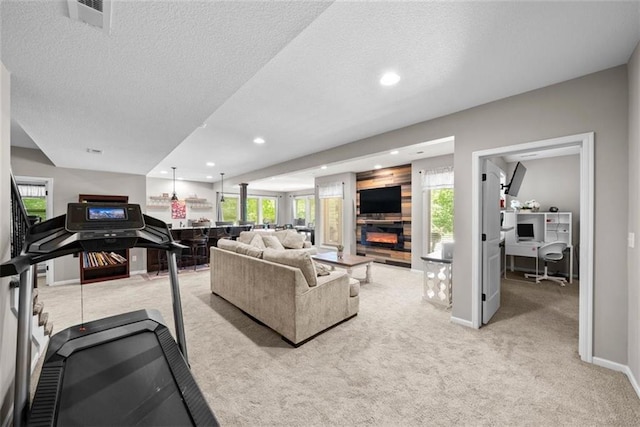 living room featuring light colored carpet, a healthy amount of sunlight, and a textured ceiling