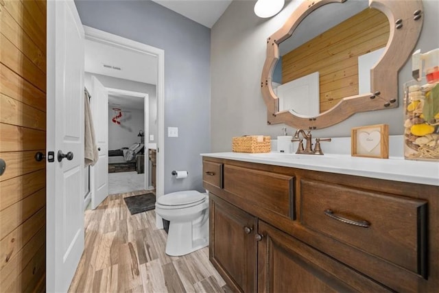 bathroom featuring vanity, hardwood / wood-style floors, and toilet