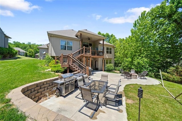 view of patio / terrace with a deck, ceiling fan, and a fire pit