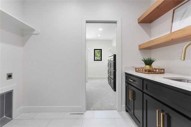 washroom featuring hookup for an electric dryer, light carpet, cabinets, and sink