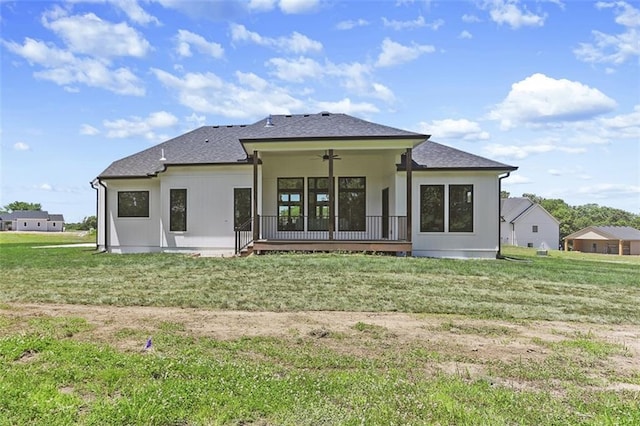 rear view of house with a lawn and ceiling fan