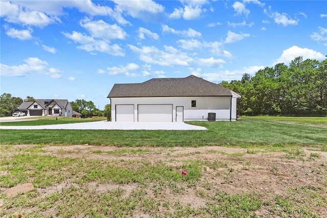 view of side of home with a lawn, a garage, and central AC